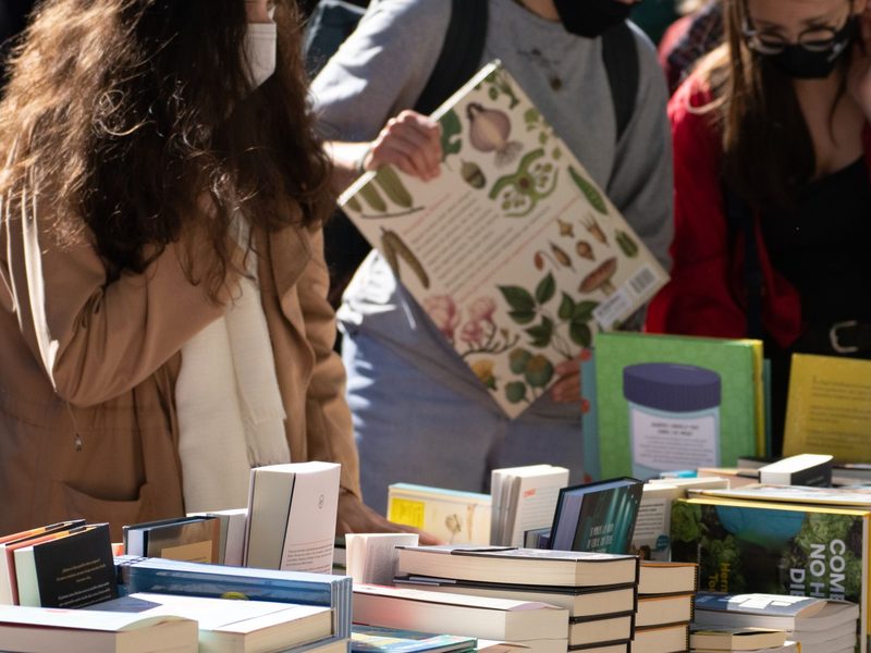 Besucher st&ouml;bern an einem Stand mit ausgelegten B&uuml;chern