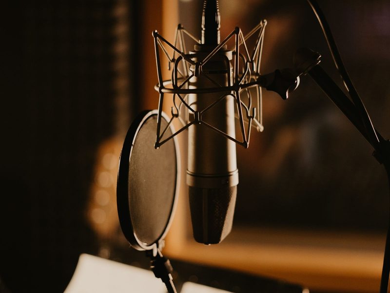 Studiomikrofon mit Popschutz vor einem Notenst&auml;nder im Tonstudio