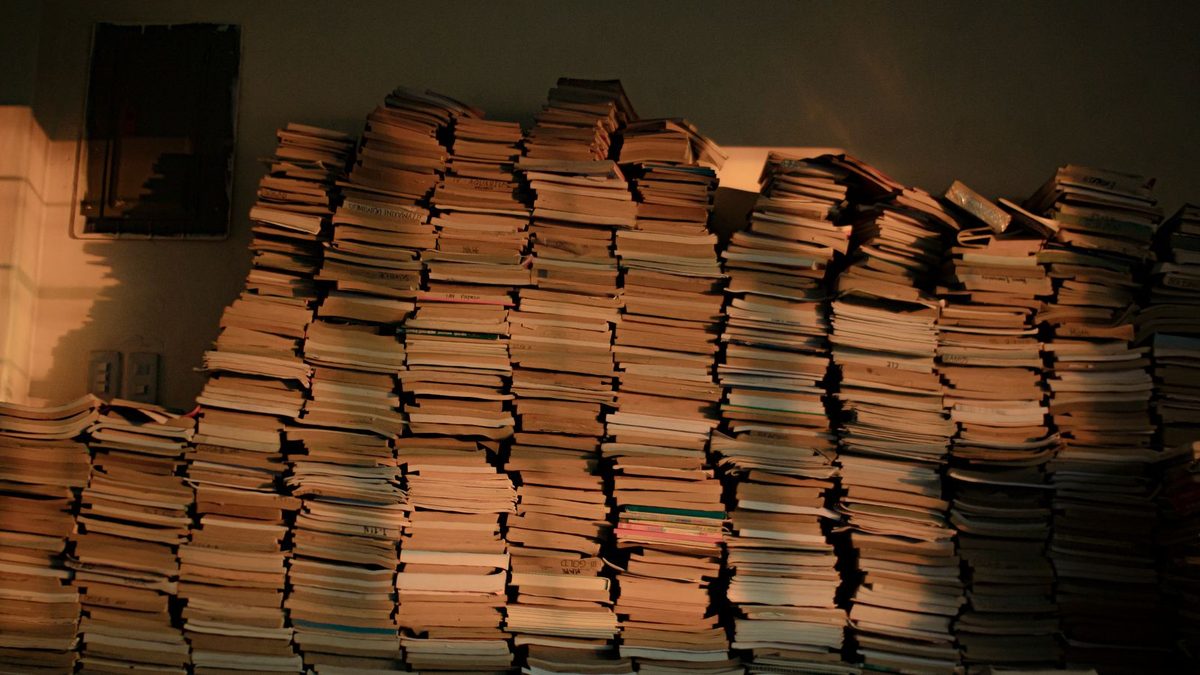 Mehrere Stapel gedruckter B&uuml;cher auf einem Tisch