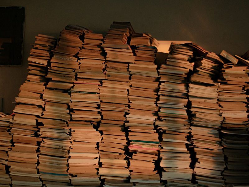 Mehrere Stapel gedruckter B&uuml;cher auf einem Tisch