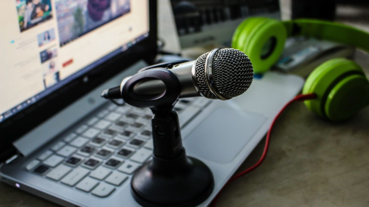 Podcast-Mikrofon vor einem aufgeklappten Laptop