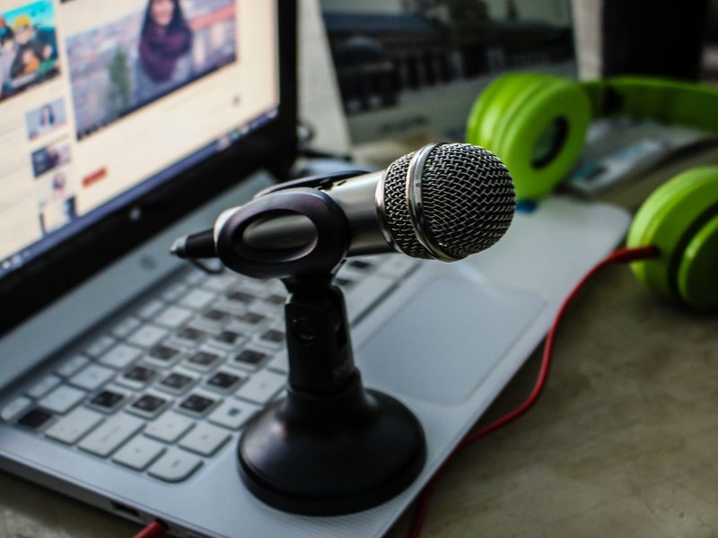 Podcast-Mikrofon vor einem aufgeklappten Laptop